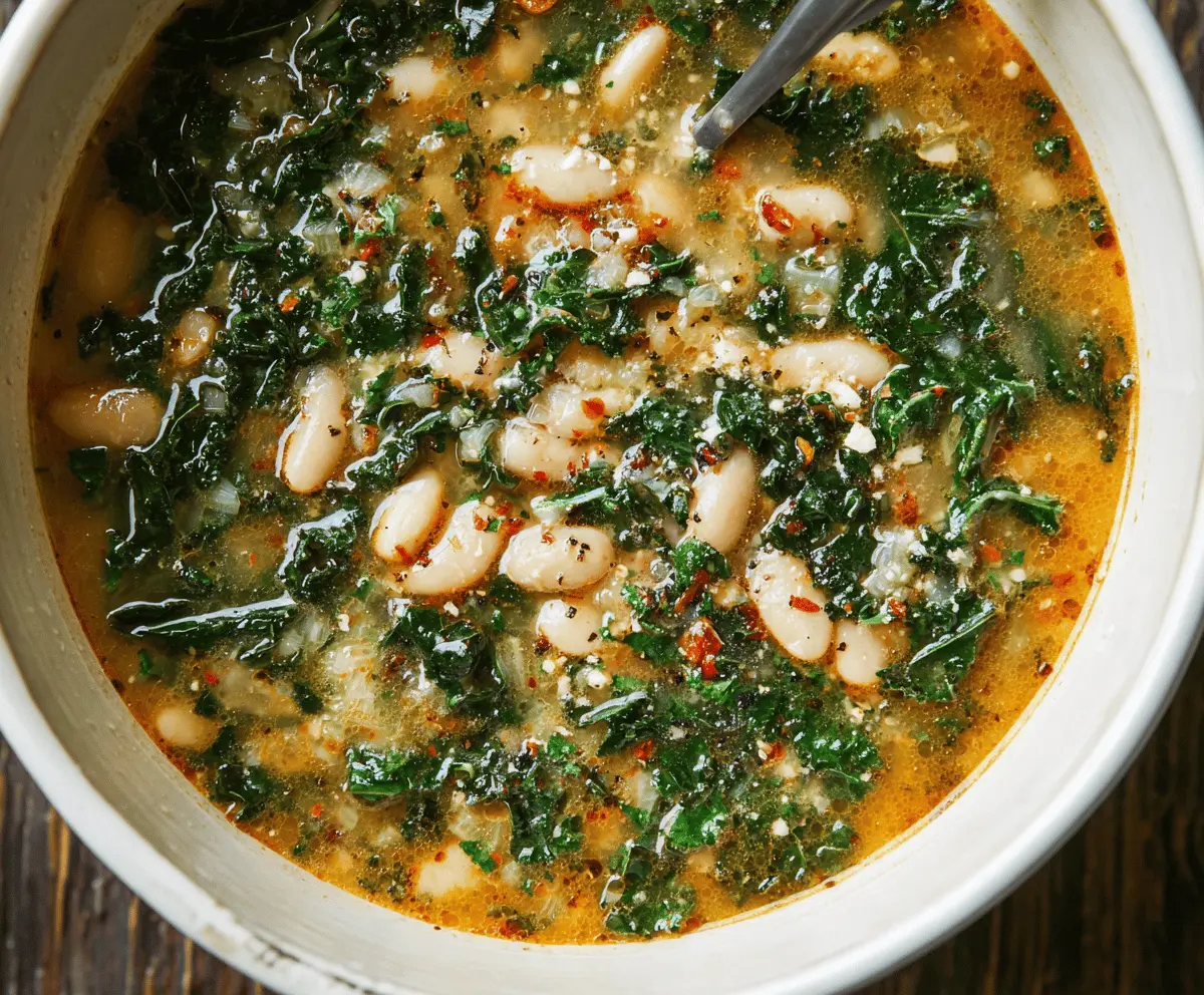 A bowl of hearty white bean and kale soup garnished with fresh herbs, showcasing a healthy and comforting meal.
