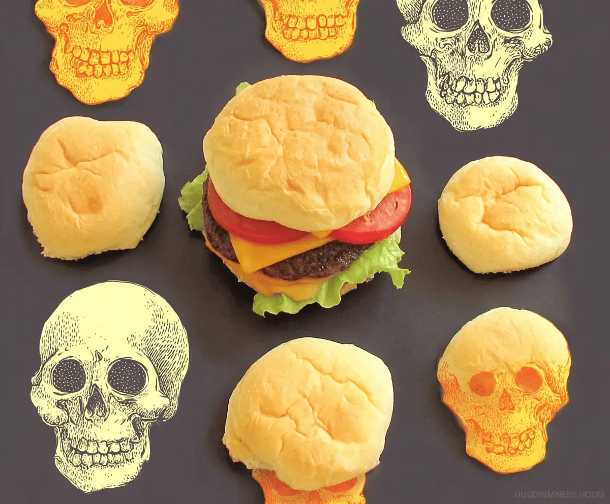 Delicious cheeseburger skull-shaped appetizers with melted cheese, lettuce, tomato, and beef patties on a plate, perfect for Halloween parties