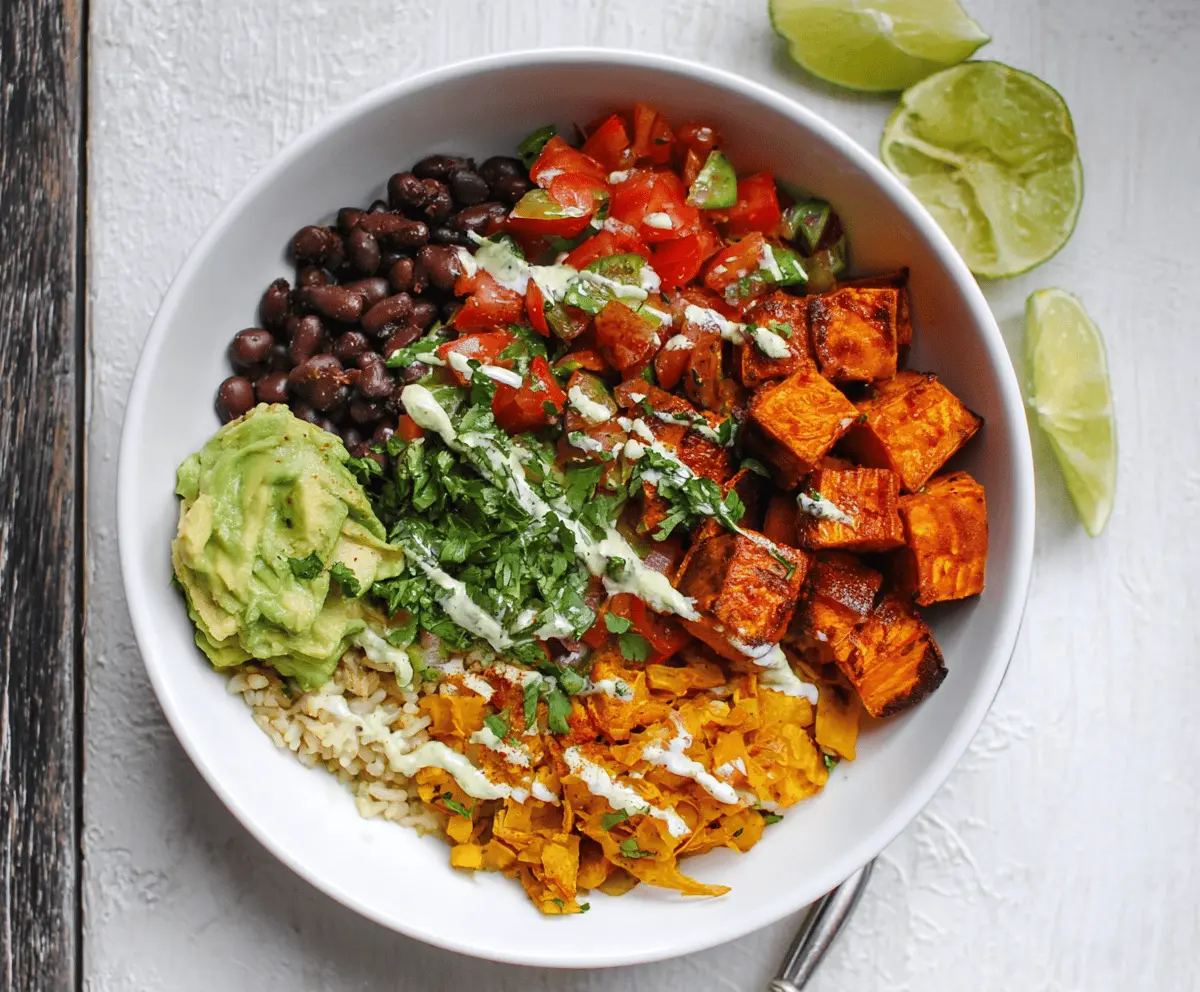 A vibrant Chipotle Sweet Potato Burrito Bowl with roasted sweet potatoes, fresh vegetables, and spicy sauce in a bowl.