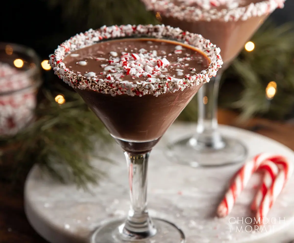 A festive Chocolate Peppermint Martini with whipped cream and crushed peppermint topping.