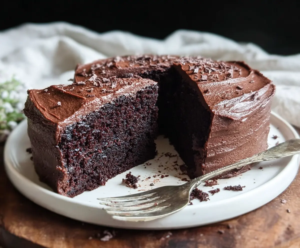 Delicious Sourdough Discard Chocolate Cake on a plate with chocolate frosting and sprinkles.