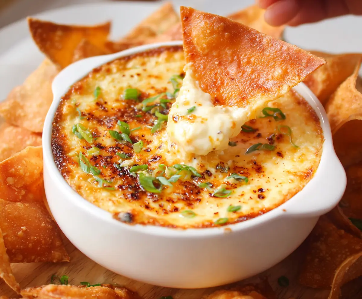 Delicious Crab Rangoon Dip served with crispy fried Wonton Chips, perfect for sharing at parties.