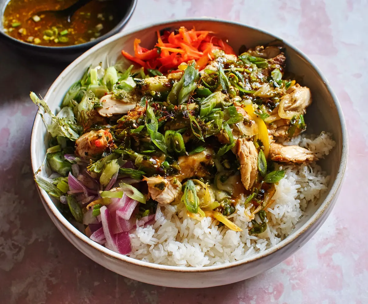 Savory Ginger Scallion Chicken Bowl with fresh herbs and colorful vegetables on a plate.