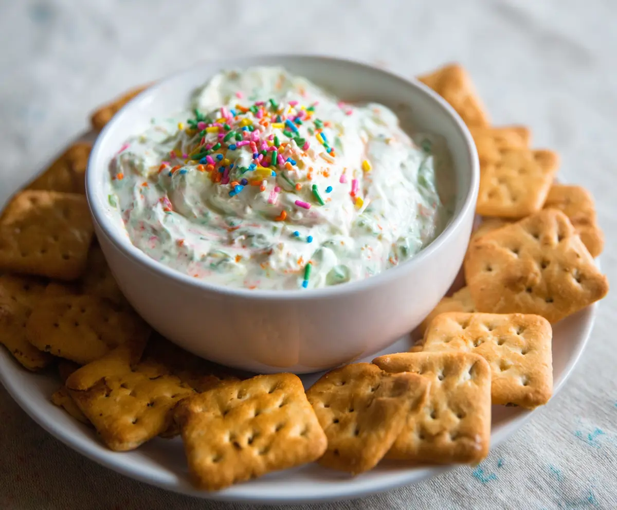 Creamy homemade Dunkaroo dip in a bowl with colorful sprinkles, perfect for dipping cookies and crackers.