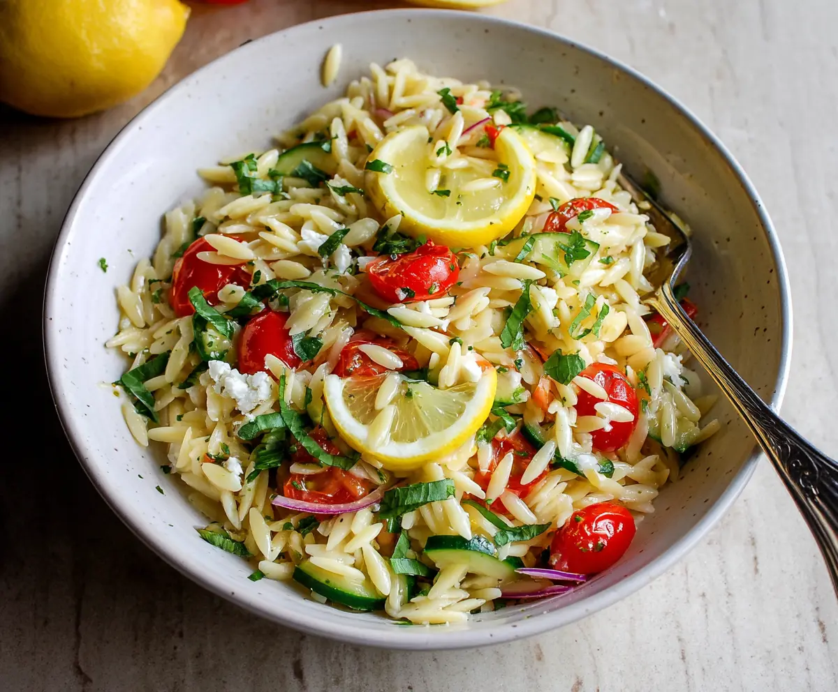 Fresh Lemon Orzo Pasta Salad with herbs and vegetables in a bowl, perfect for summer lunch.